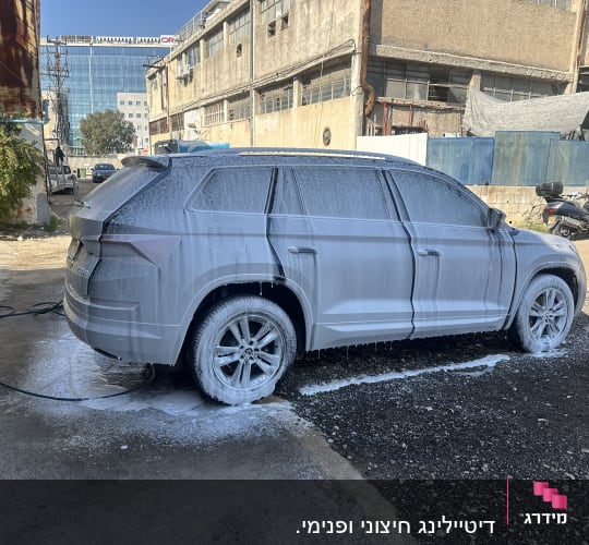 רכב מכוסה בקצף שטיפה בחניון פתוח